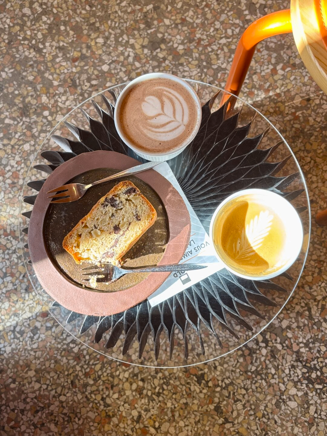 Table avec cafés latte art et cake chez Bold Coffee